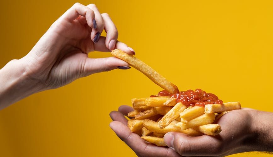 person sharing french fries